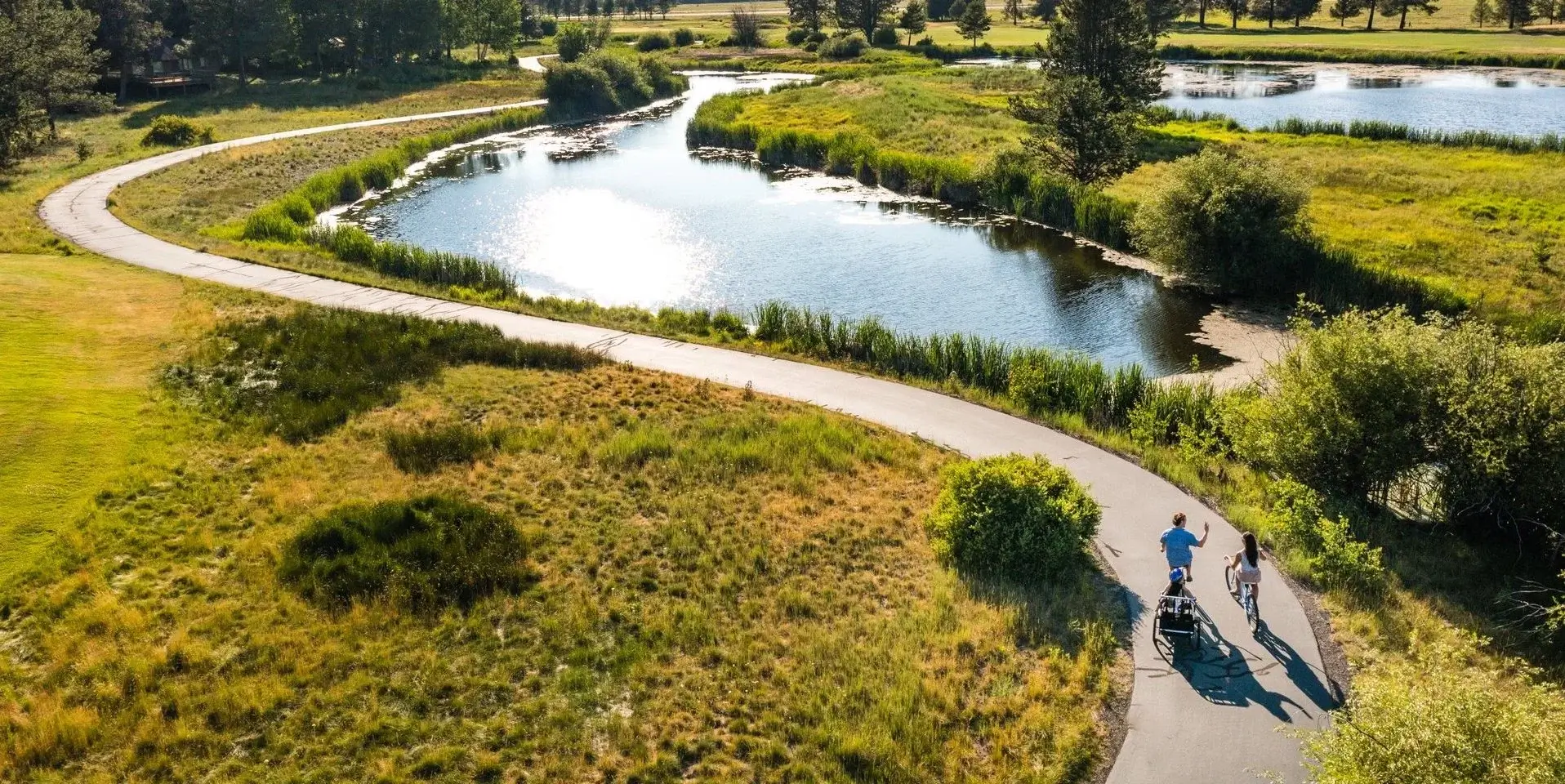 Family biking on a paved path through trees