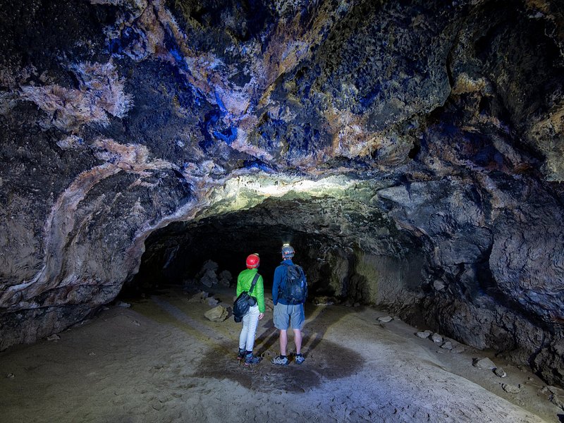Tour group inside a narrow lava tube